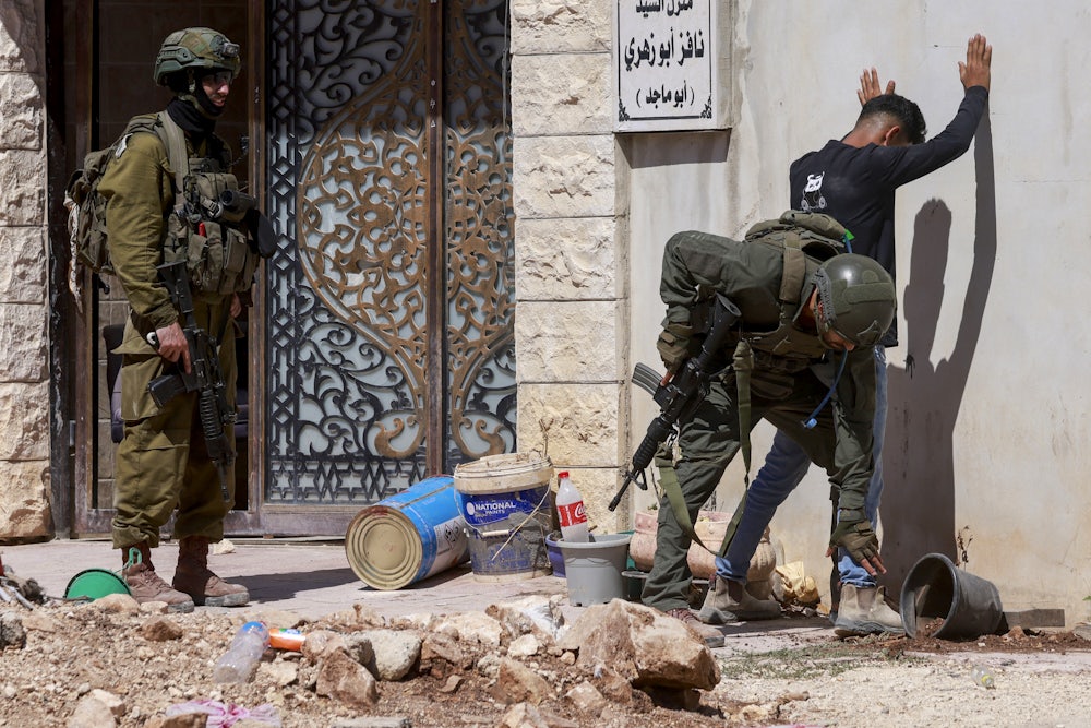 Israeli soldiers check a Palestinian man at the entrance of Tulkarem camp, in the occupied West Bank, during a military operation on July 6, 2025.