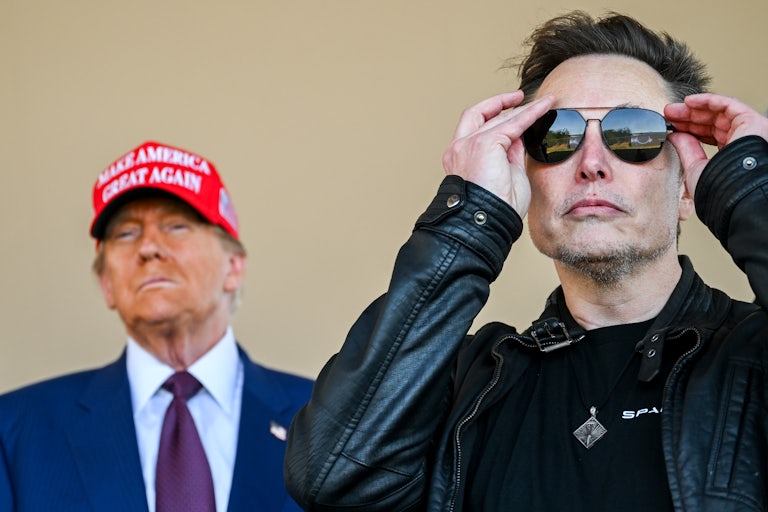 Donald Trump stands next to Elon Musk, who is putting on sunglasses