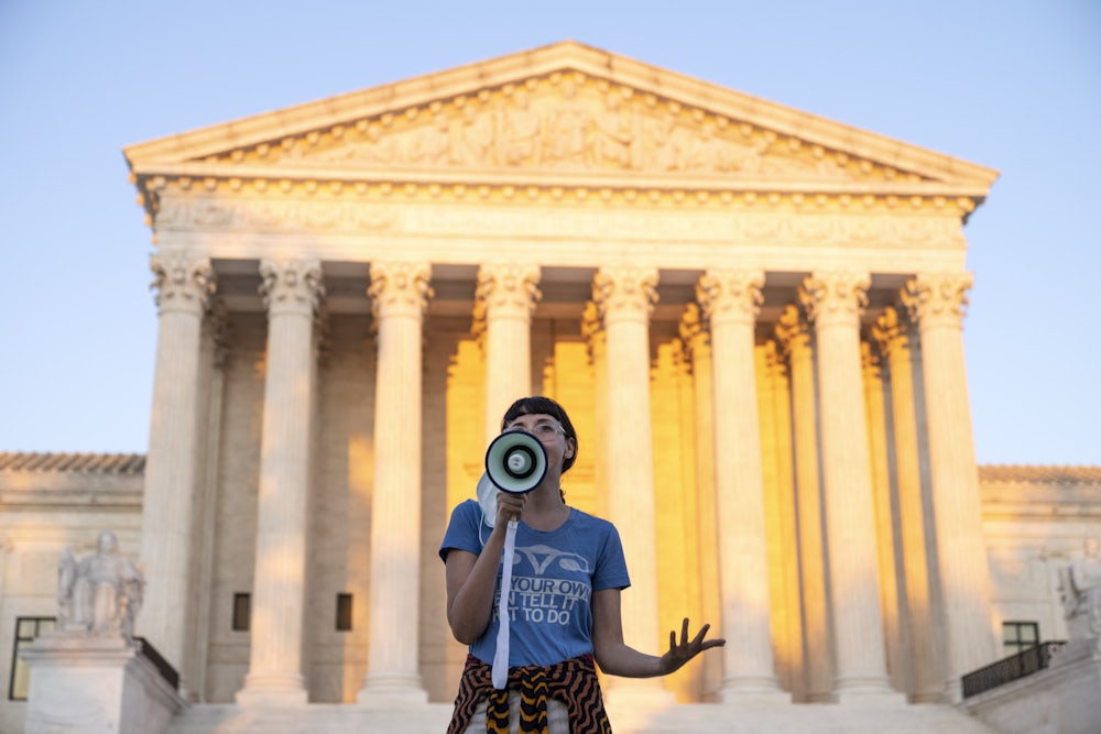 An activist speaks into a megaphone outside the Supreme Court in protest against the new Texas abortion law.