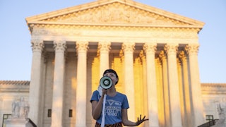 An activist speaks into a megaphone outside the Supreme Court in protest against the new Texas abortion law.