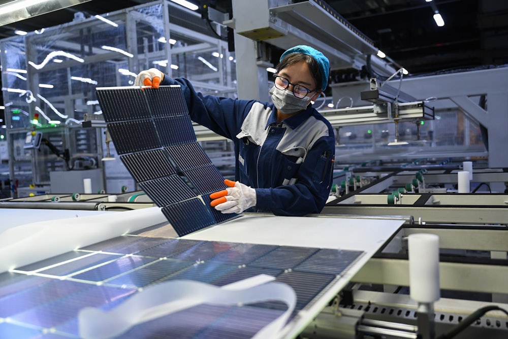 A staff member checks monocrystalline silicon wafers at JA Solar Technology Co. Ltd., in Baotou, north China's Inner Mongolia Autonomous Region, As an old industrial city, Baotou is now vigorously developing new industries in the fields of rare earth and new energy such as photovoltaics and wind power.