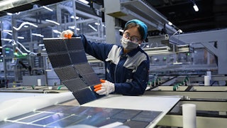 A staff member checks monocrystalline silicon wafers at JA Solar Technology Co. Ltd., in Baotou, north China's Inner Mongolia Autonomous Region, As an old industrial city, Baotou is now vigorously developing new industries in the fields of rare earth and new energy such as photovoltaics and wind power.