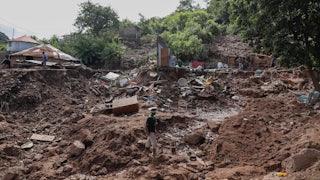 A man walks on rubble.