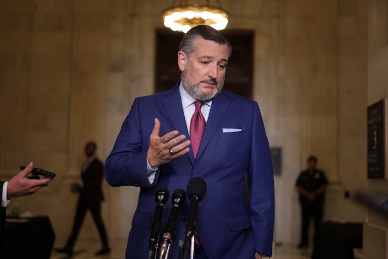 Texas Senator Ted Cruz looks downward and shrugs. Press surrounds him.