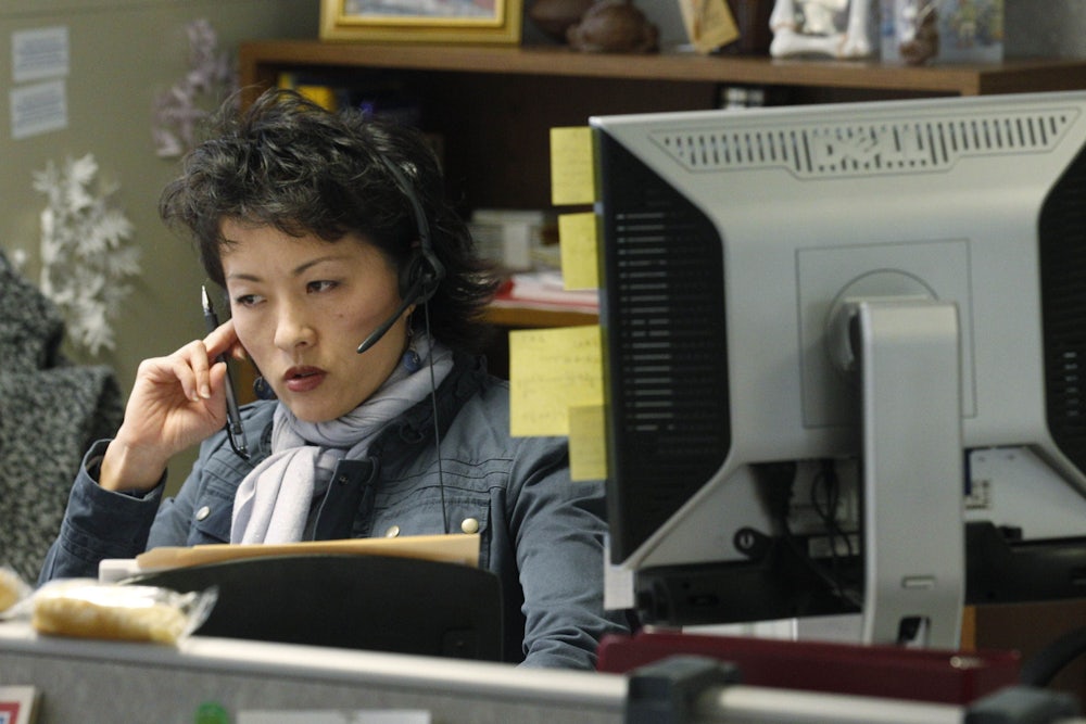 a woman with a headset and a computer monitor at a mental health call center