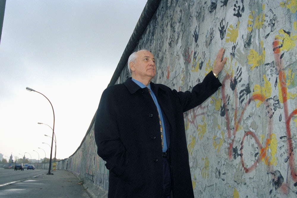 Mikhail Gorbachev stands next to the Berlin Wall in 1998.