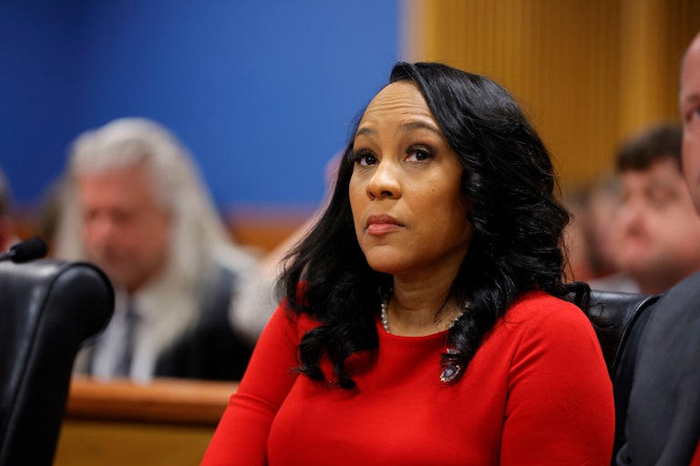 Fani Willis looks up while sitting in a courtroom