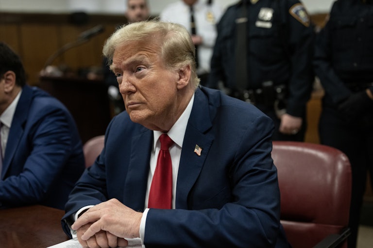 Donald Trump sits with his hands folded