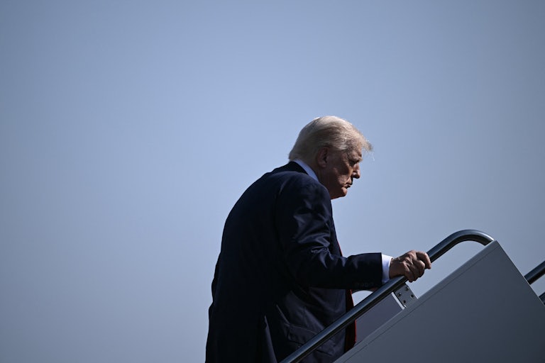 Donald Trump looks down while boarding Air Force One