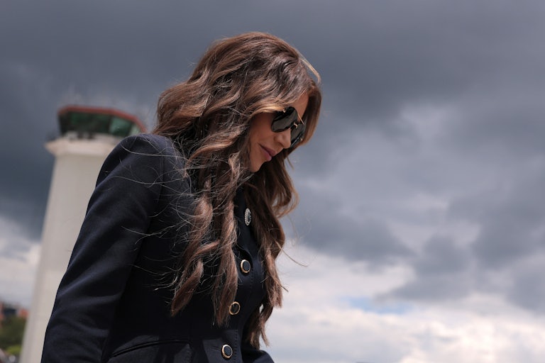 Homeland Security Secretary Kristi Noem looks down while walking on an airport tarmac