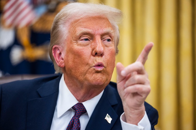 Donald Trump gestures and speaks while sitting in the Oval Office