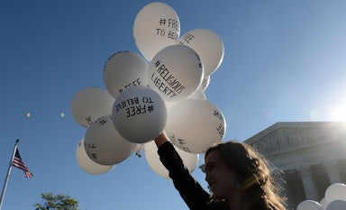 A protester holds balloons calling for religious freedom outside the Supreme Court.