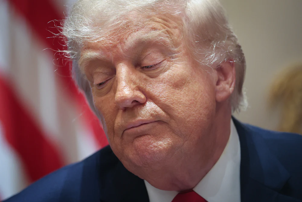Donald Trump looks to the side while sitting in his Cabinet meeting