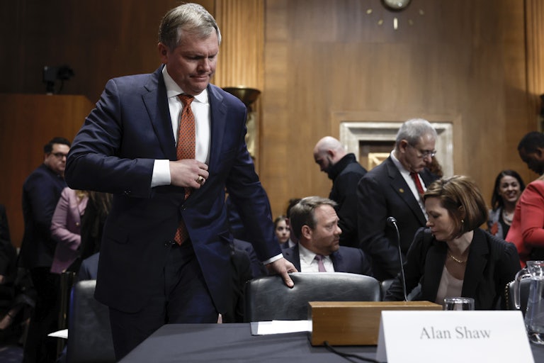 Alan Shaw pulls out his chair to sit down.