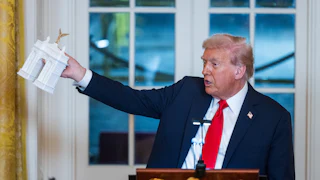 Donald Trump holds a model of the planned Triumph Arch during a dinner in the East Room of the White House.