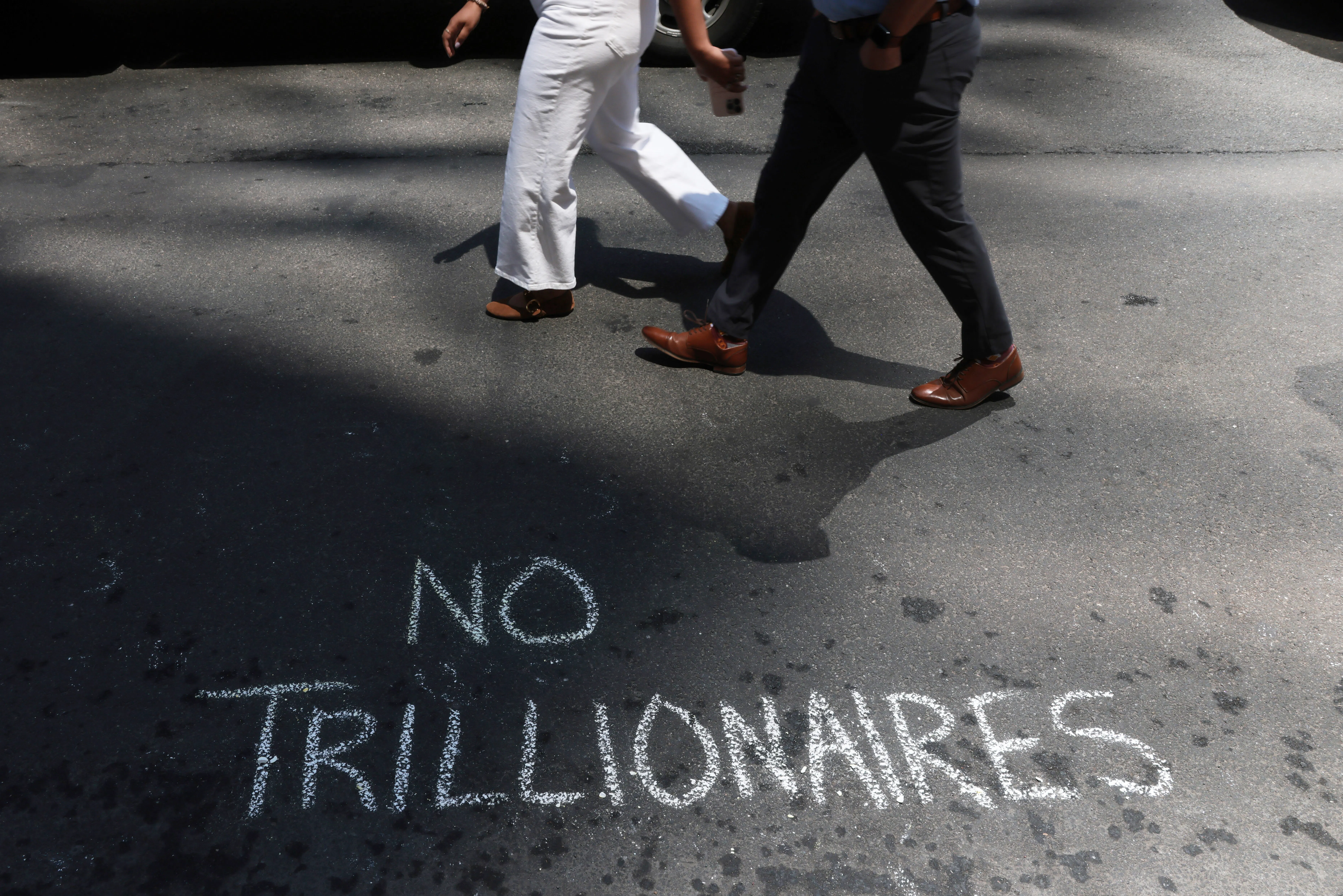 Protesters leave messages in chalk as they demonstrated against Elon Musk and his extensive wealth following the launch of the SpaceX initial public offering on the Nasdaq. 