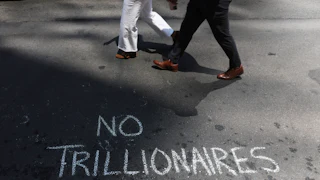 Protesters leave messages in chalk as they demonstrated against Elon Musk and his extensive wealth following the launch of the SpaceX initial public offering on the Nasdaq.