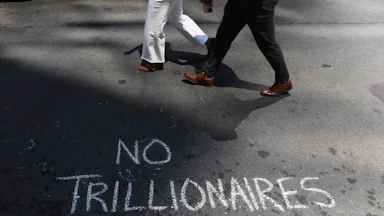 Protesters leave messages in chalk as they demonstrated against Elon Musk and his extensive wealth following the launch of the SpaceX initial public offering on the Nasdaq.