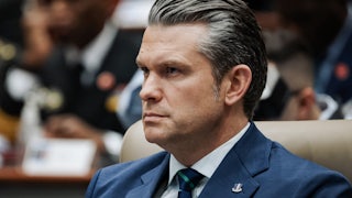 Defense Secretary Pete Hegseth sits during an event