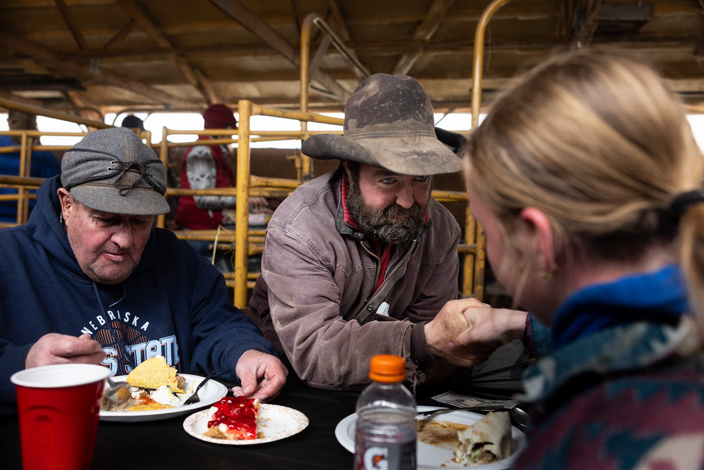 Three cattle workers take a break for lunch.