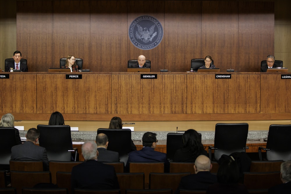 Five people sit behind a panel under the seal of the Securities and Exchange Commission.
