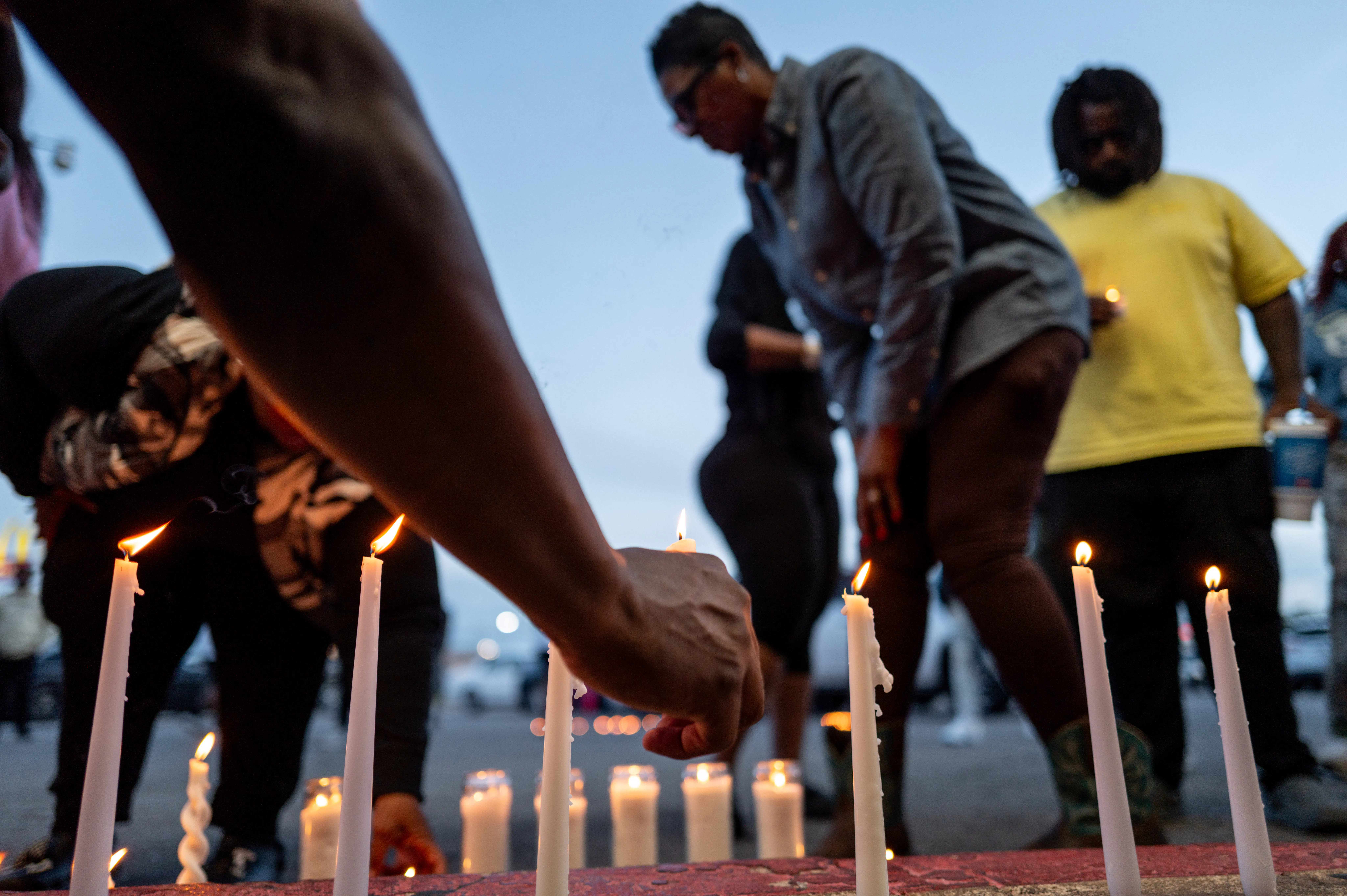 People light candles at a vigil for the victims of a mass shooting in Shreveport, Louisiana