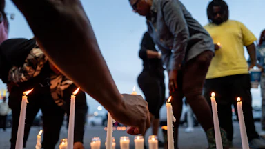 People light candles at a vigil for the victims of a mass shooting in Shreveport, Louisiana