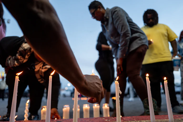 People light candles at a vigil for the victims of a mass shooting in Shreveport, Louisiana