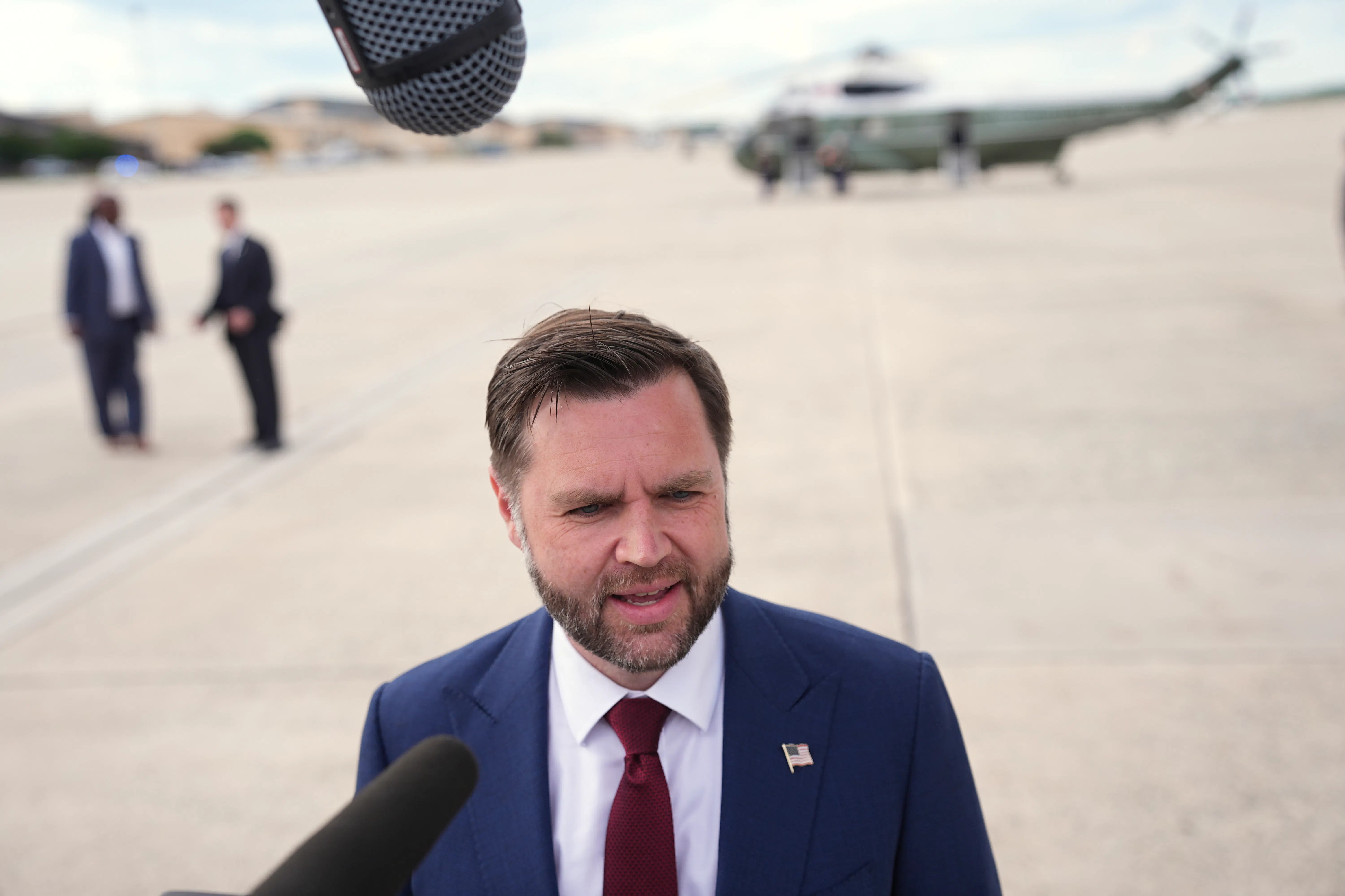 Vice President JD Vance speaks to reporters on an airport tarmac