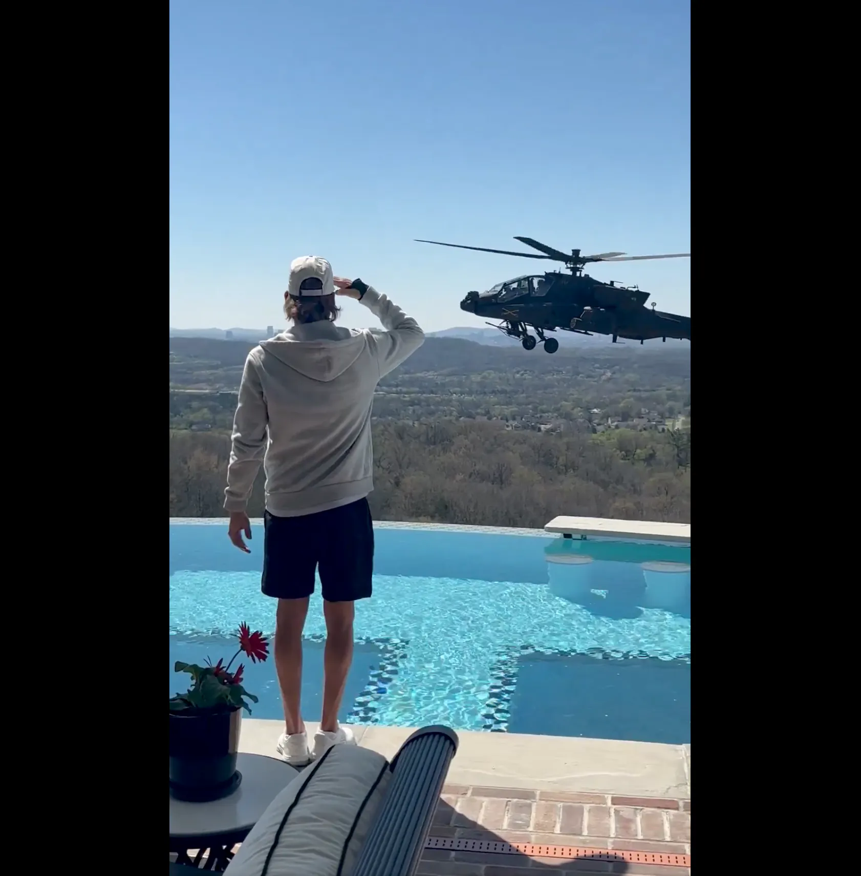 Kid Rock salutes an Army helicopter hovering by his pool