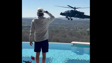 Kid Rock salutes an Army helicopter hovering by his pool