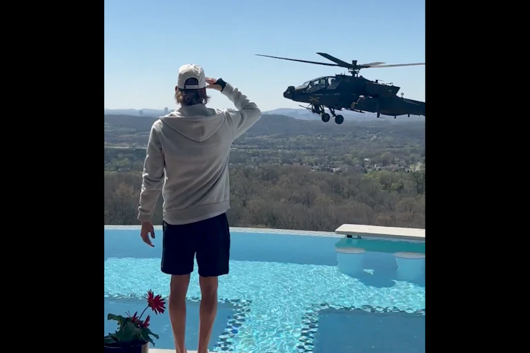 Kid Rock salutes an Army helicopter hovering by his pool