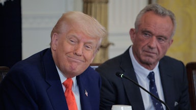 Donald Trump smiles as he sits next to Health and Human Services Secretary Robert F. Kennedy Jr..