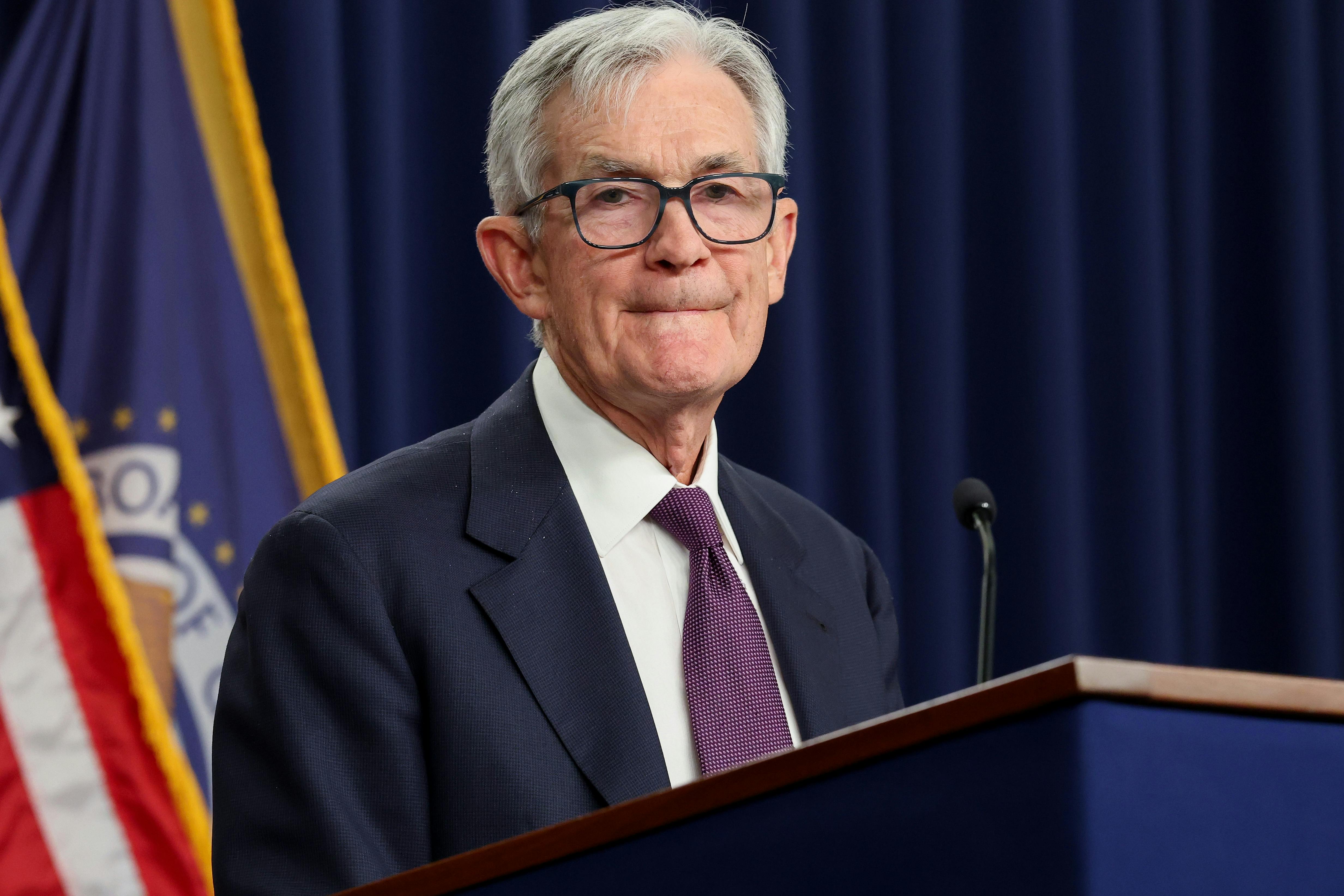 Federal Reserve Chair Jerome Powell purses his lips while standing behind a podium.