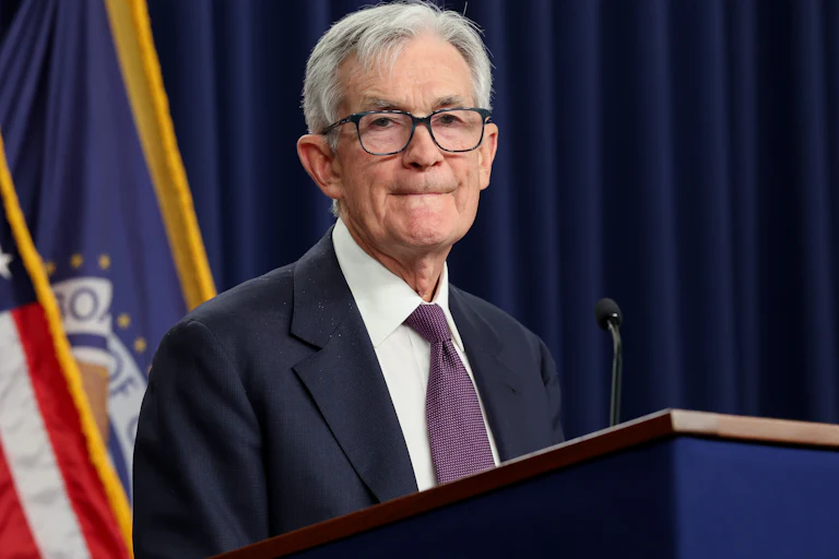 Federal Reserve Chair Jerome Powell purses his lips while standing behind a podium.