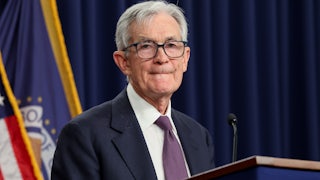 Federal Reserve Chair Jerome Powell purses his lips while standing behind a podium.