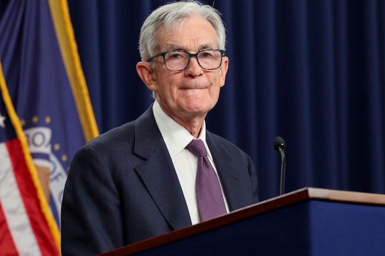 Federal Reserve Chair Jerome Powell purses his lips while standing behind a podium.