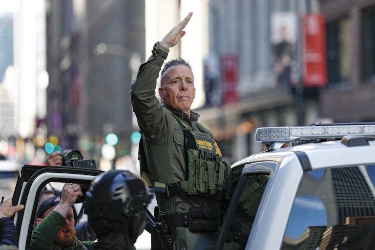 CBP Chief Gregory Bovino raises his hand while getting into a car outside the federal courthouse in Chicago