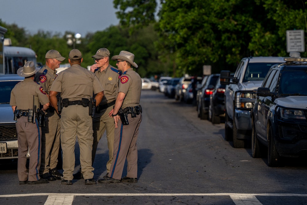 Law enforcement officers gather outside of Robb Elementary School following the mass shooting that killed 19 students and 2 adults.