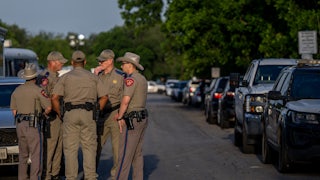 Law enforcement officers gather outside of Robb Elementary School following the mass shooting that killed 19 students and 2 adults.
