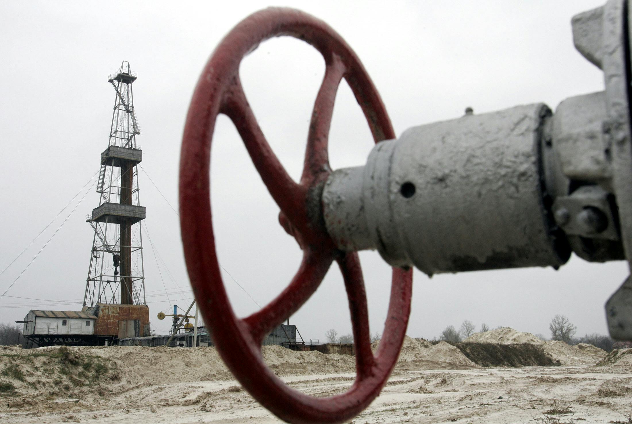 A wheel to shut off a valve appears in the foreground, with further infrastructure in the background.