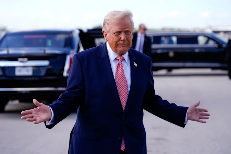 Donald Trump holds his hands out to the side and makes a weird face