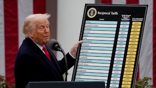 Donald Trump holds up a chart of tariffs while standing at a podium during a press conference in the White House Rose Garden
