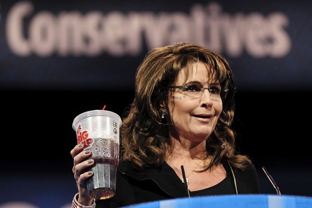 A close up of Sarah Palin holding a soda.