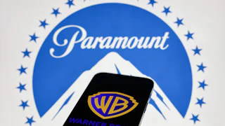 A phone with the Warner Bros. logo and a laptop screen with the Paramount logo
