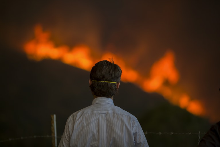 A man watches flames approach from the Woolsey Fire in California in 2018.