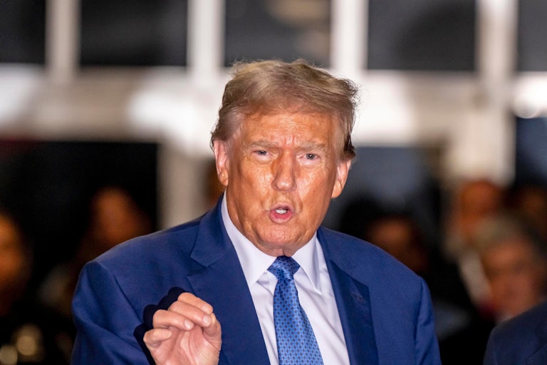 Donald Trump speaks, brows furrowed, and makes a gesture with his right hand for emphasis