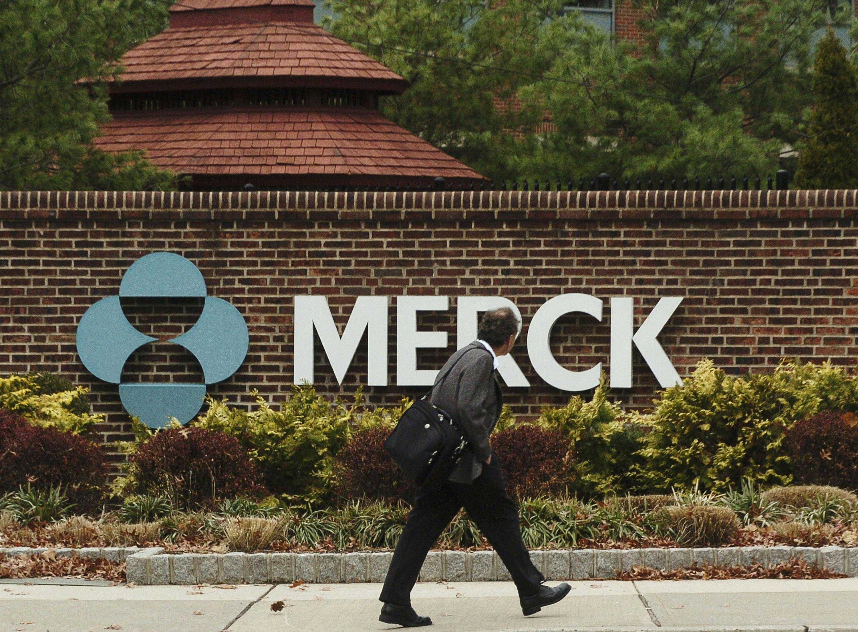 A man walks past the front of the Merck Pharmaceuticals plant in Rahway, New Jersey.