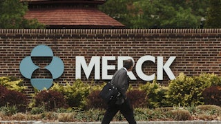 A man walks past the front of the Merck Pharmaceuticals plant in Rahway, New Jersey.
