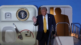 Donald Trump waves as he gets off Air Force One.